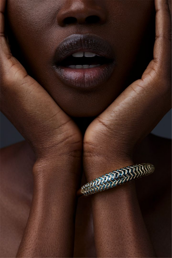 model wearing Cuff bracelet with gold and blue shaded gems in zigzag pattern