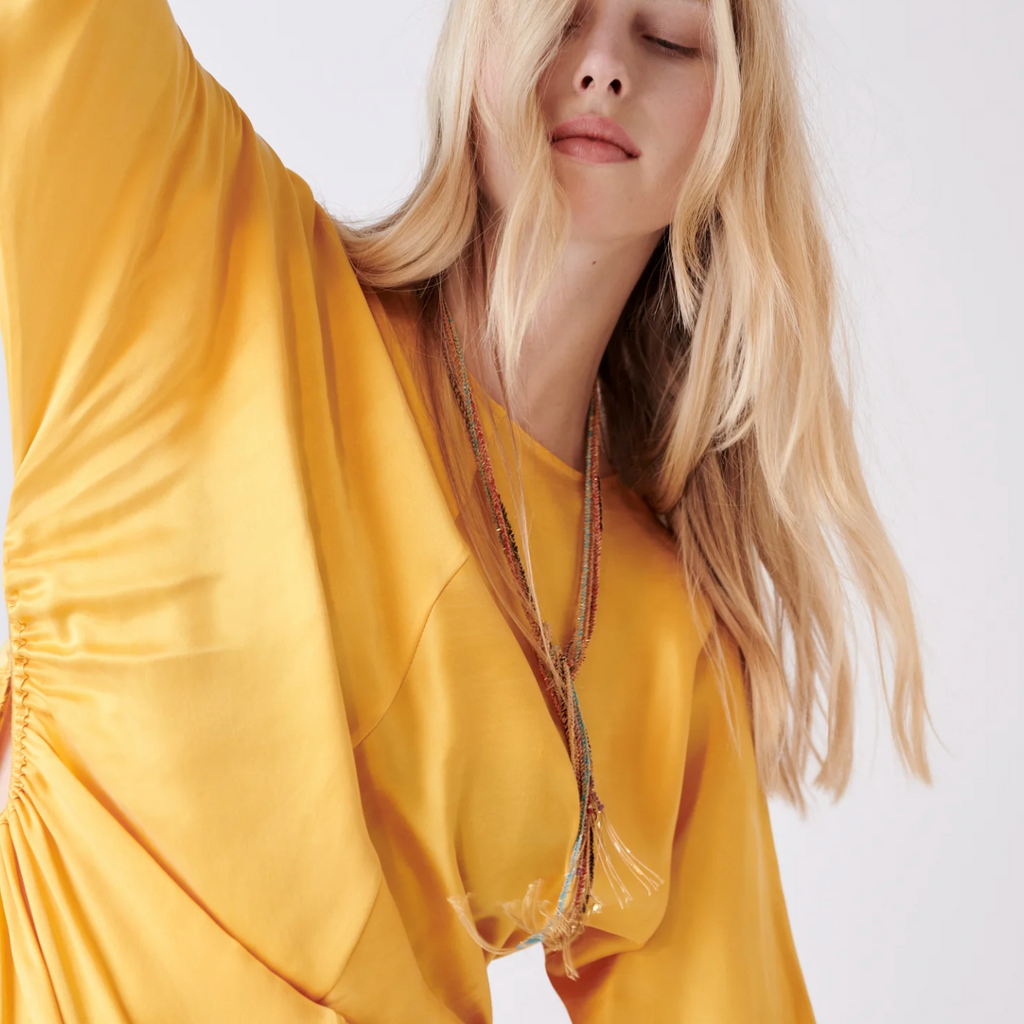 blonde model wearing multiple silk rope and gold necklaces