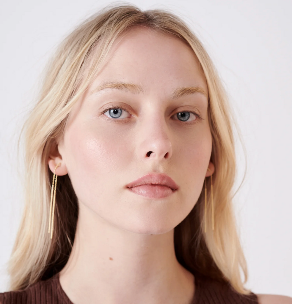 model wearing gold drop earrings