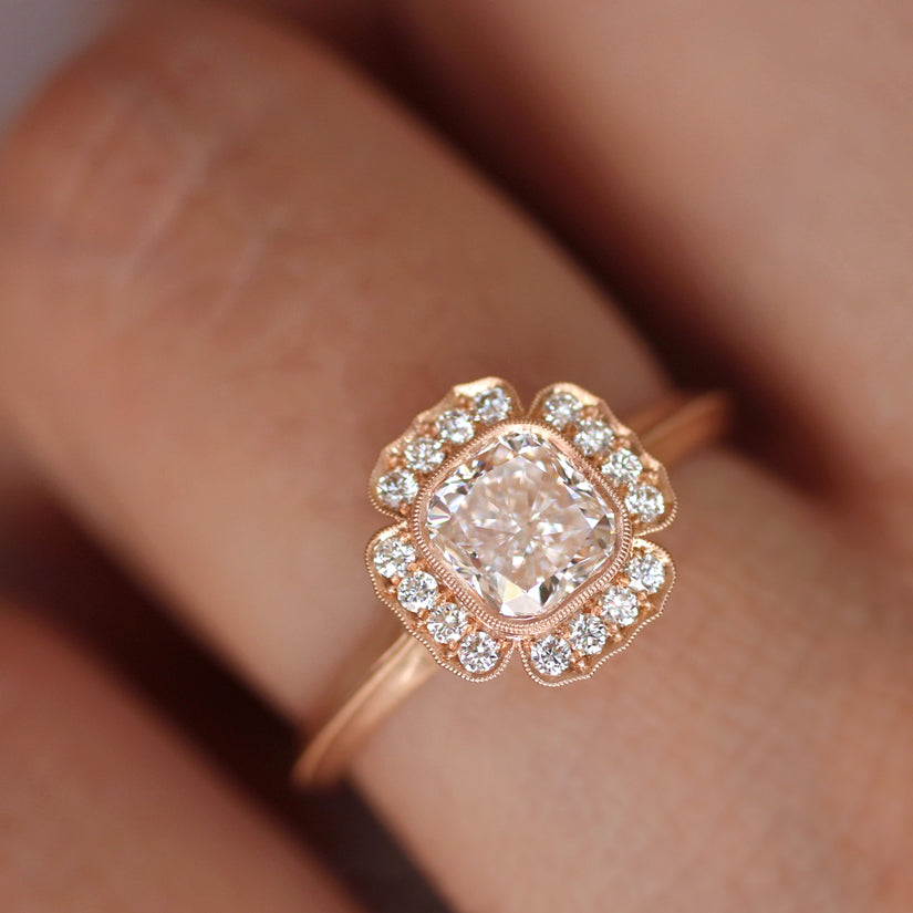 rose gold diamond halo ring on a hand