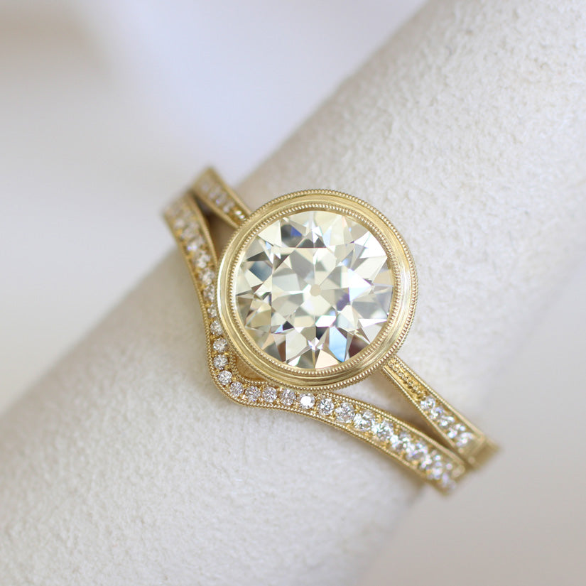 diamond bezel and curved diamond and gold engagement ring