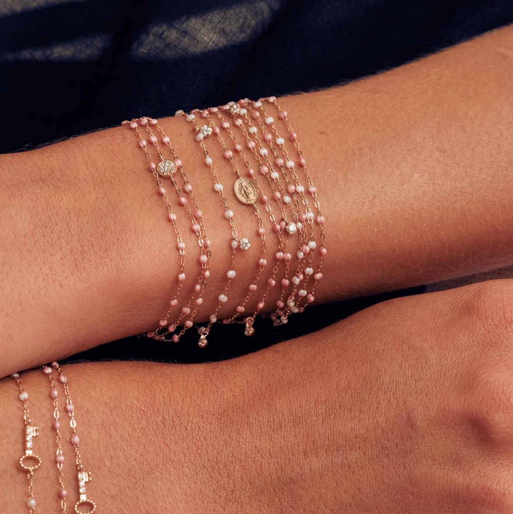 model wearing gold, diamond, and pink beaded bracelets