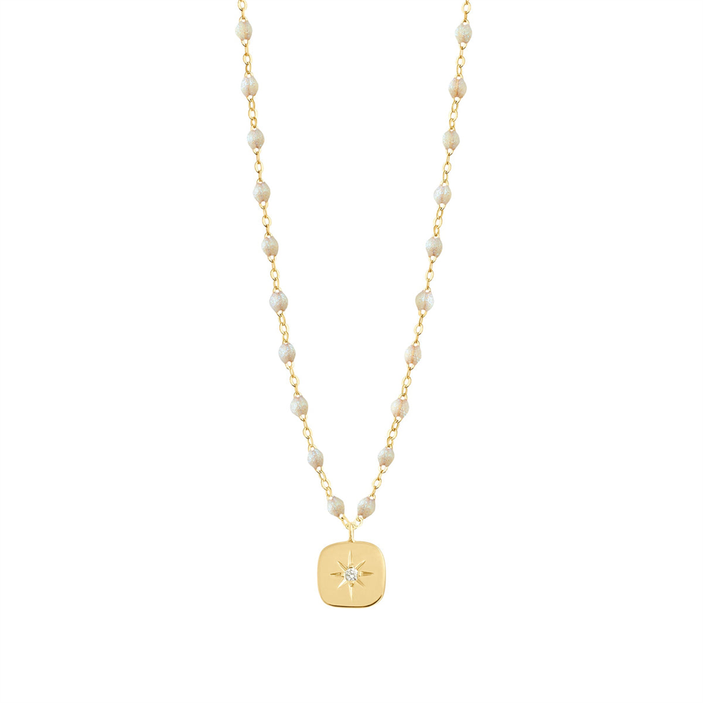 white beaded and gold necklace with gold charm with star and diamond center