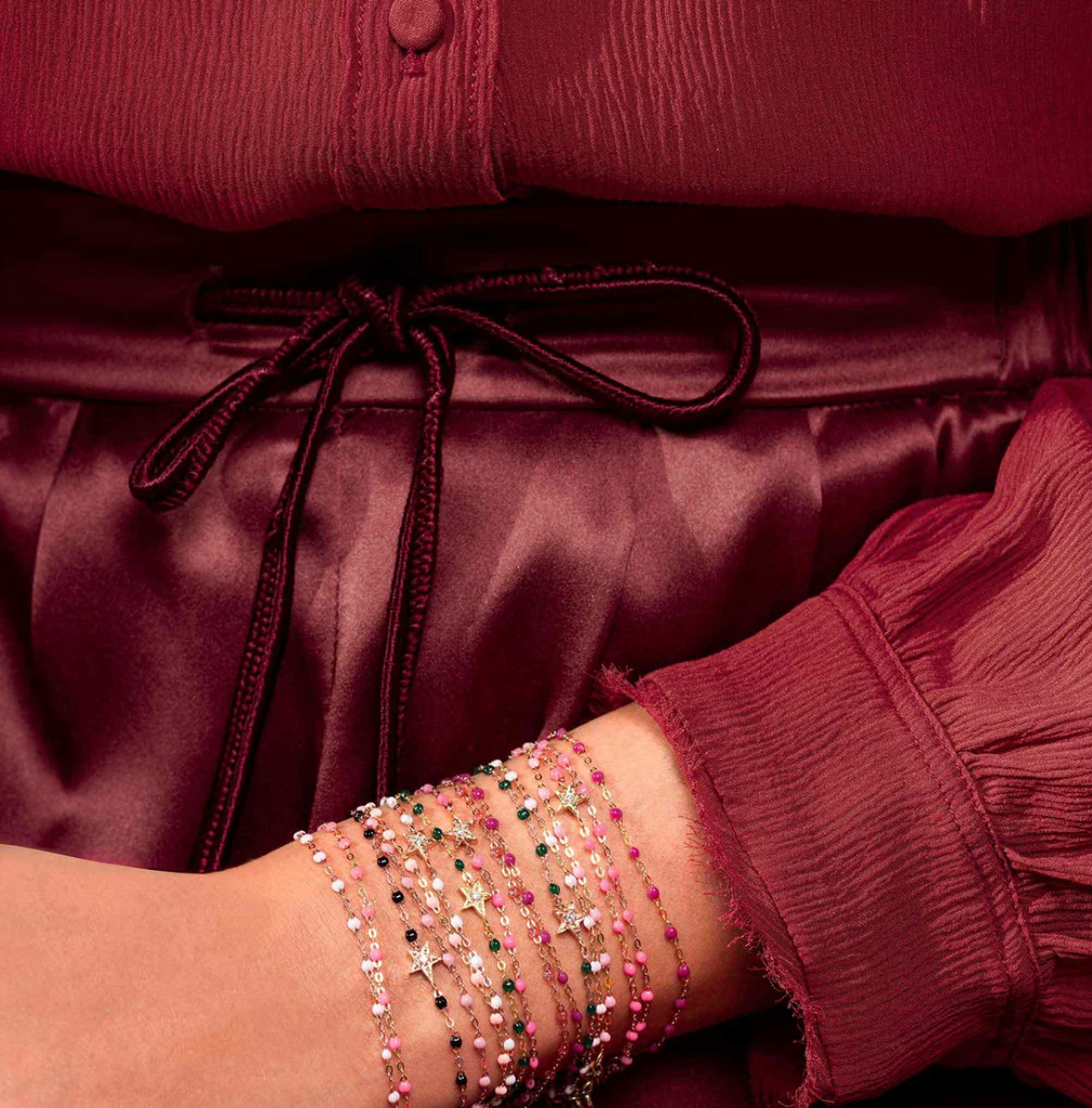 model wearing multiple gold and colored beaded bracelets