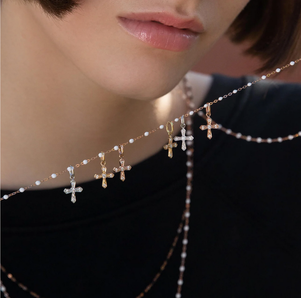model holding white beaded necklace with multiple gold and white gold diamond pendants