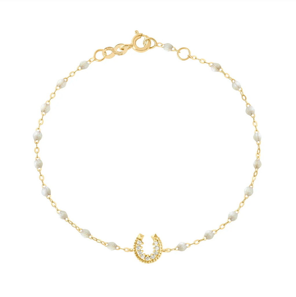 dainty gold and opal beaded bracelet with a diamond and gold horseshoe charm