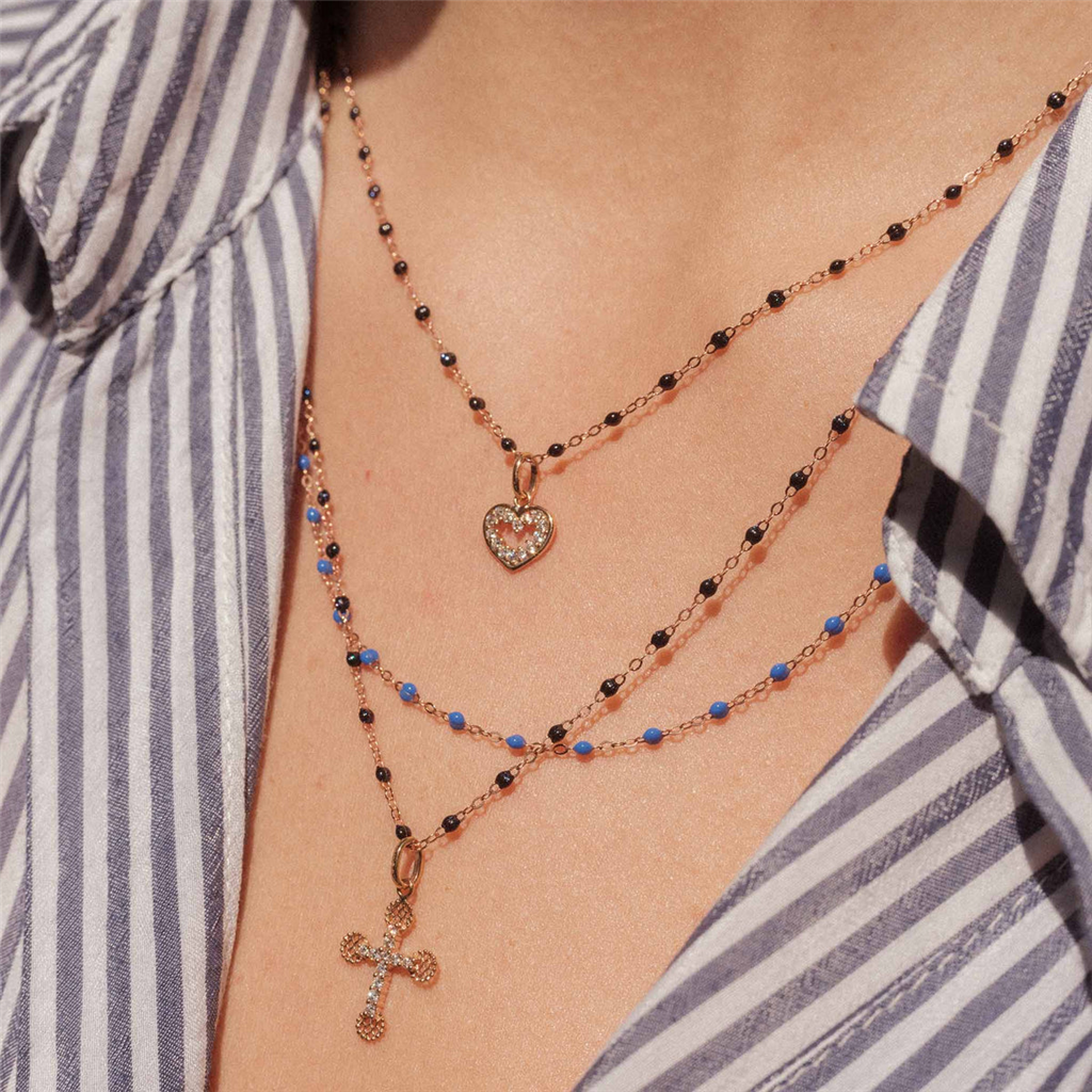 model wears beaded necklaces with heart and cross pendants