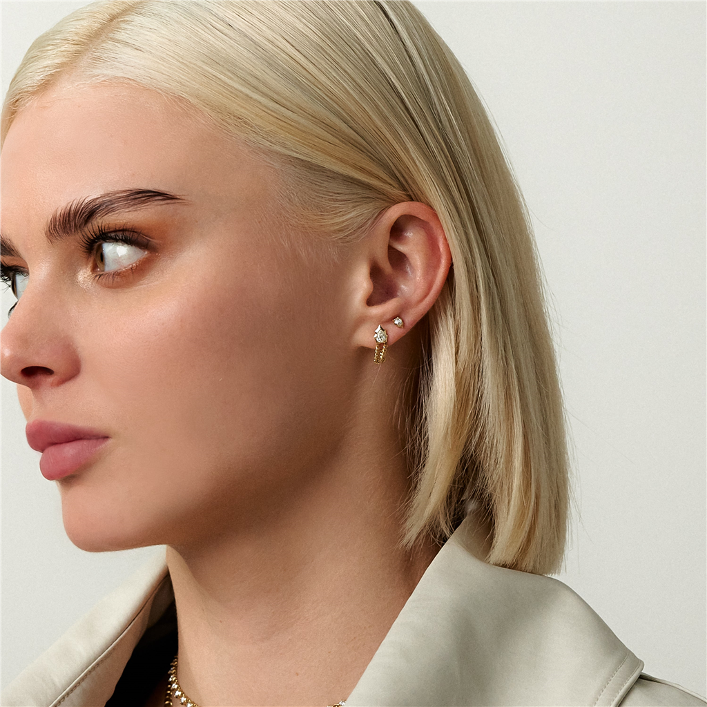 model wearing gold chain loop earrings with pear shaped diamond