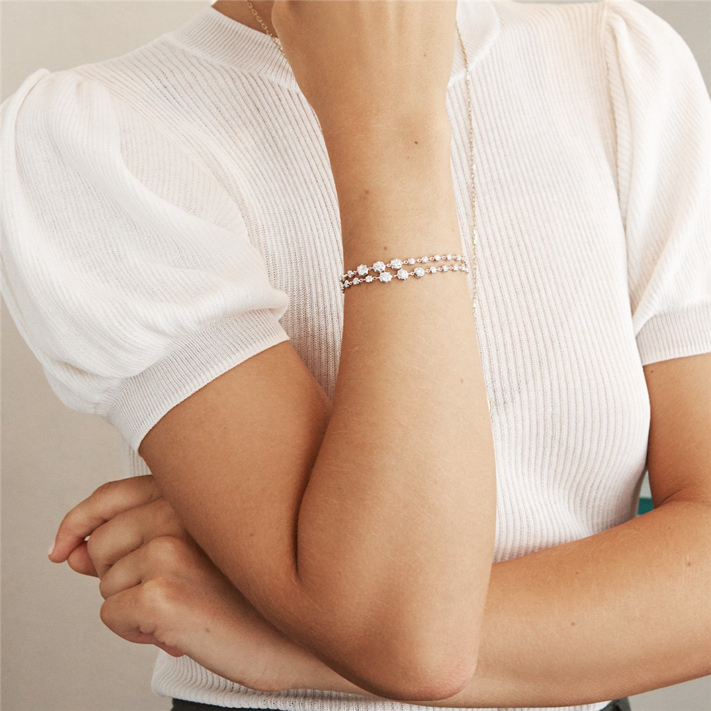 model wearing 2 graduated diamond and gold bracelets