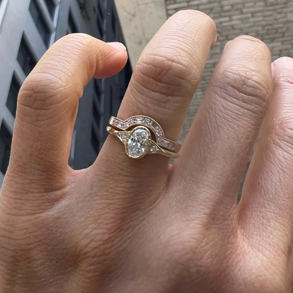 model wearing diamond oval ring and arch diamond and gold band