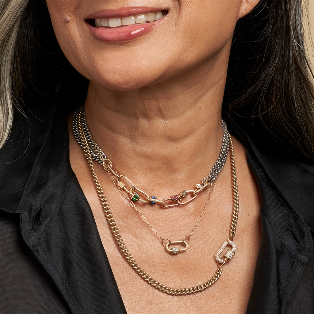model wearing chain link necklaces and gold and diamond locks