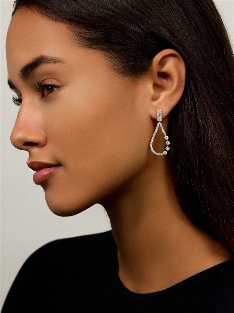 model wearing gold and diamond drop earrings