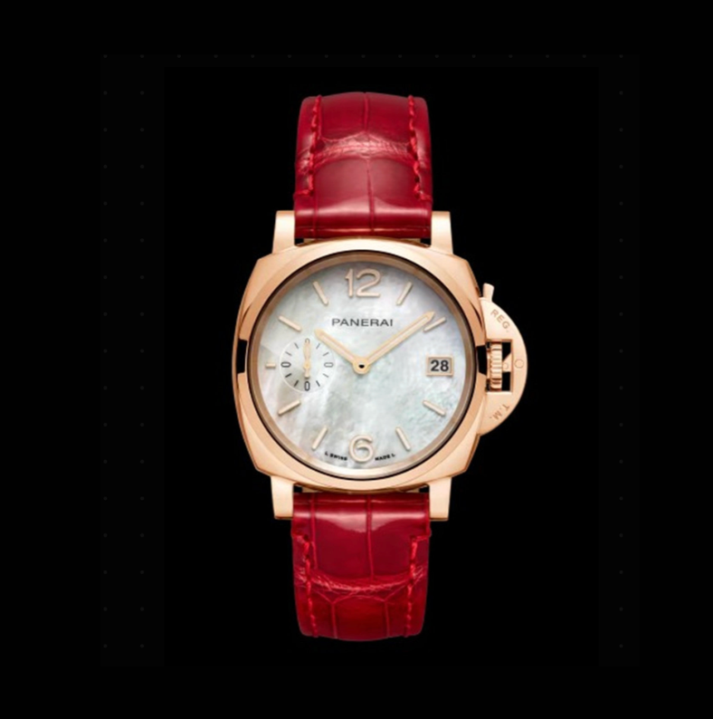 Luxury watch with red strap and gold casing on a black background