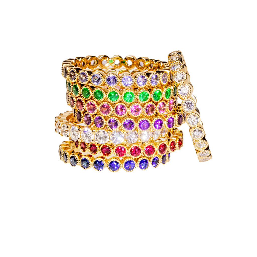 stack of eternity bands with varying gemstones
