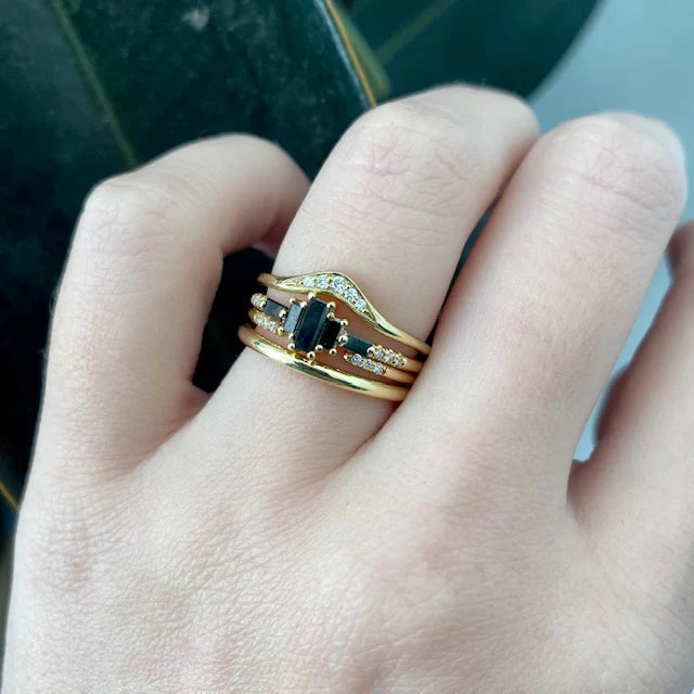 model wearing black diamond ring with 3 gold and diamond bands
